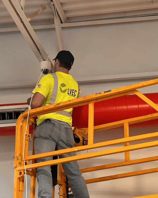 LVEC technician on a lift installing a dome camera