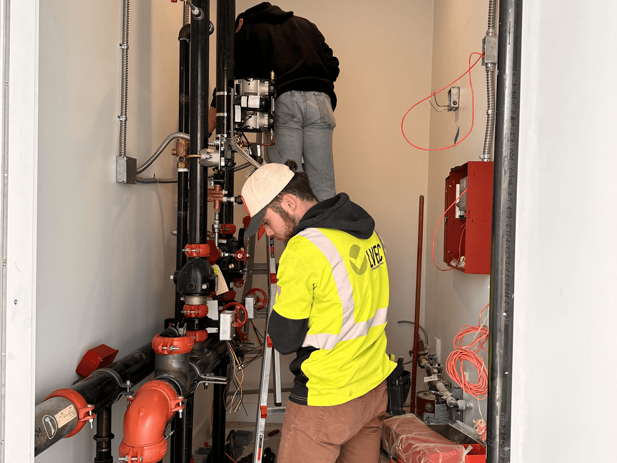 Two LVEC technicians working in a fire sprinkler riser room